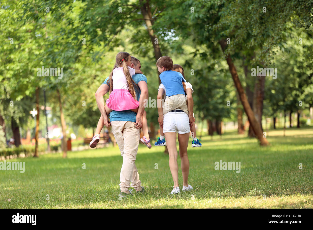 Happy family walking together in green park Stock Photo - Alamy