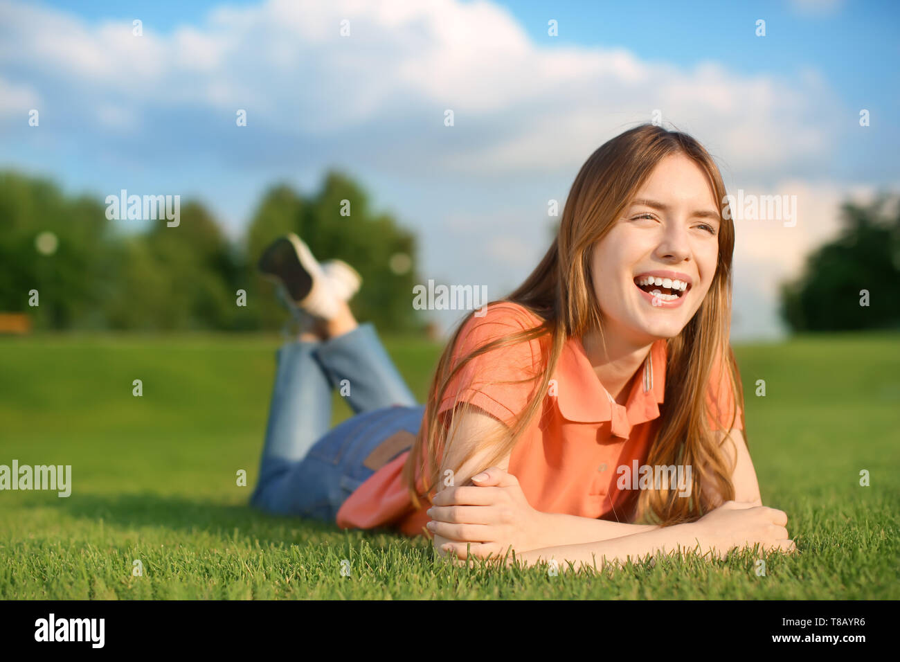 Young woman lying on green grass outdoors Stock Photo - Alamy
