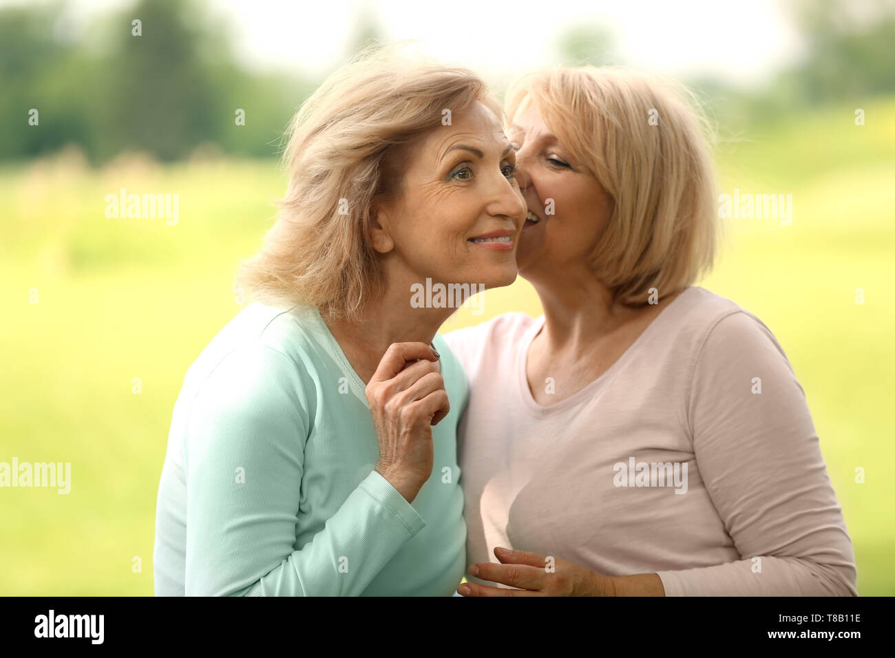 Happy mature women gossiping outdoors Stock Photo