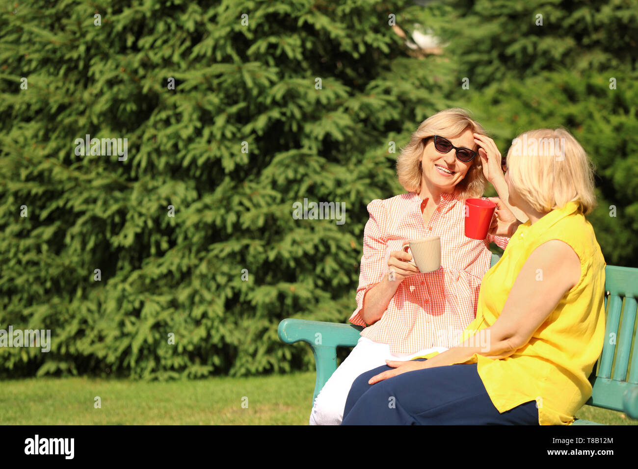 Beautiful mature women resting on bench in park Stock Photo - Alamy