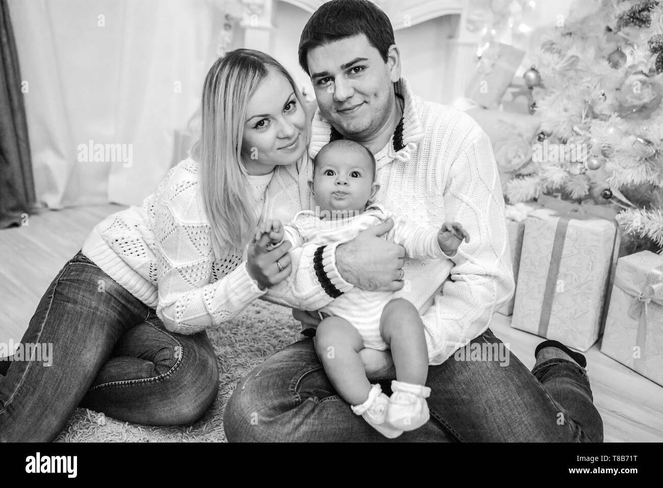 happy parents kiss their baby on Christmas eve. the concept of happiness Stock Photo