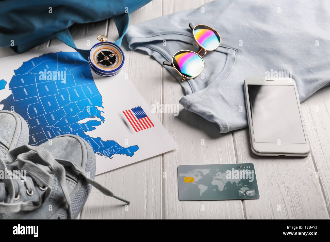 Composition with USA map, credit card, mobile phone and clothes on wooden background Stock Photo