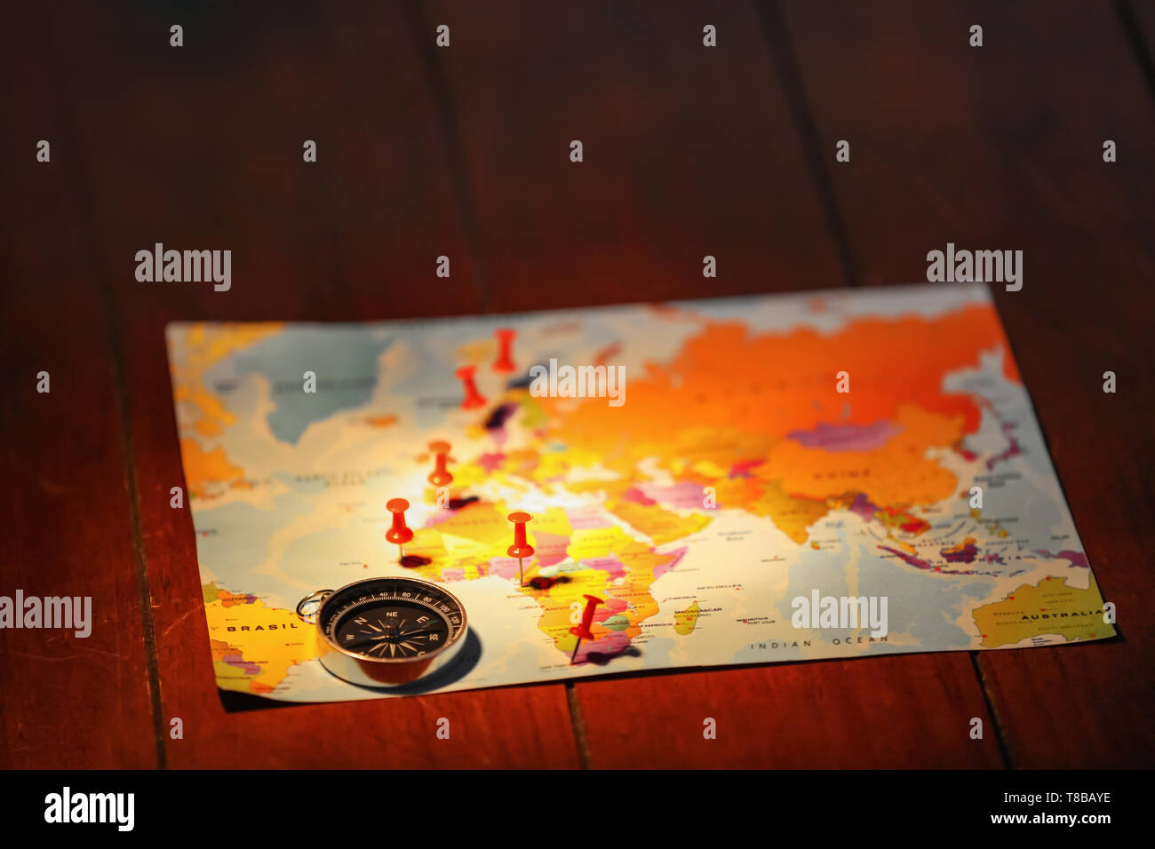 World map with compass and pushpins on table Stock Photo