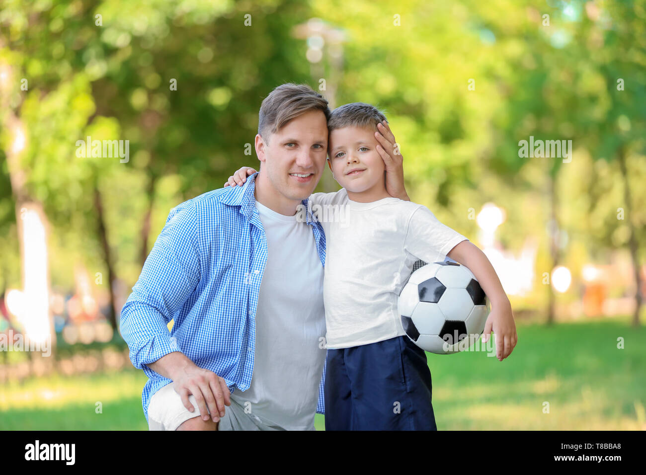 Little boy and his dad with soccer ball in park Stock Photo ...