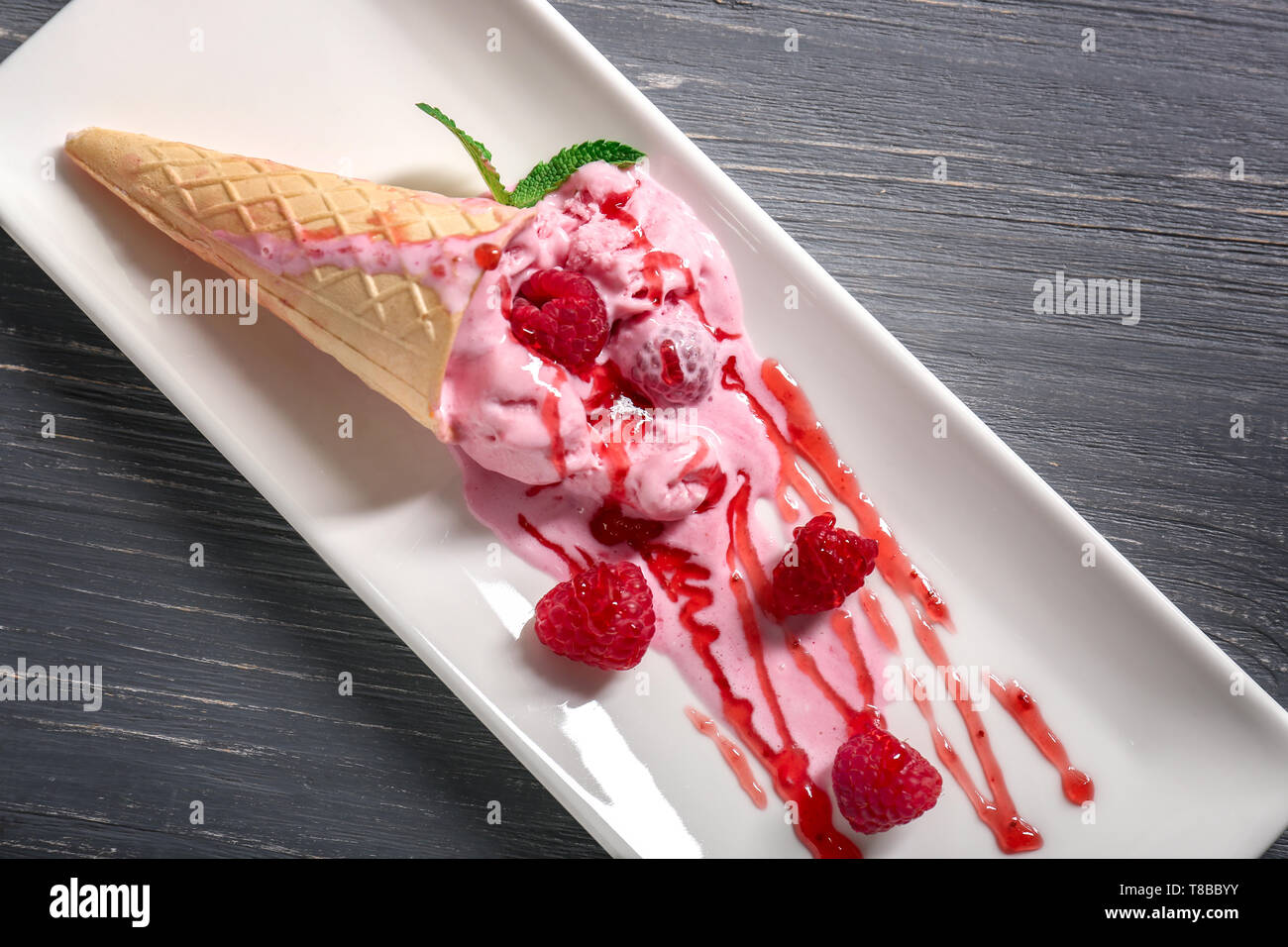 Waffle cone with delicious raspberry ice-cream on plate Stock Photo - Alamy