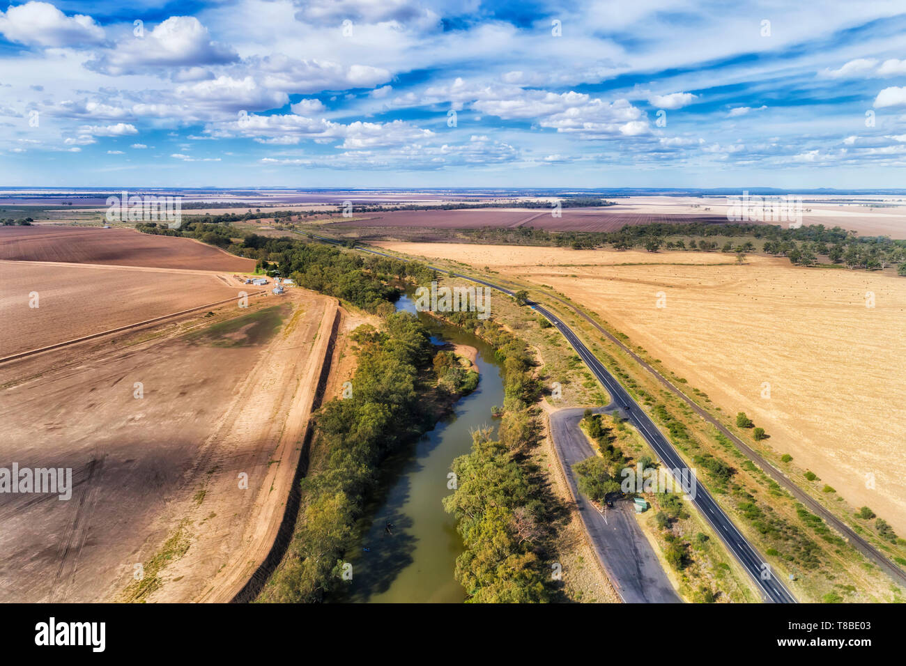 Newell highway off Moree town in Artesian basin of Australian wheat belt at flat plains of developed agriculture farms along Gwydir river with rest ar Stock Photo