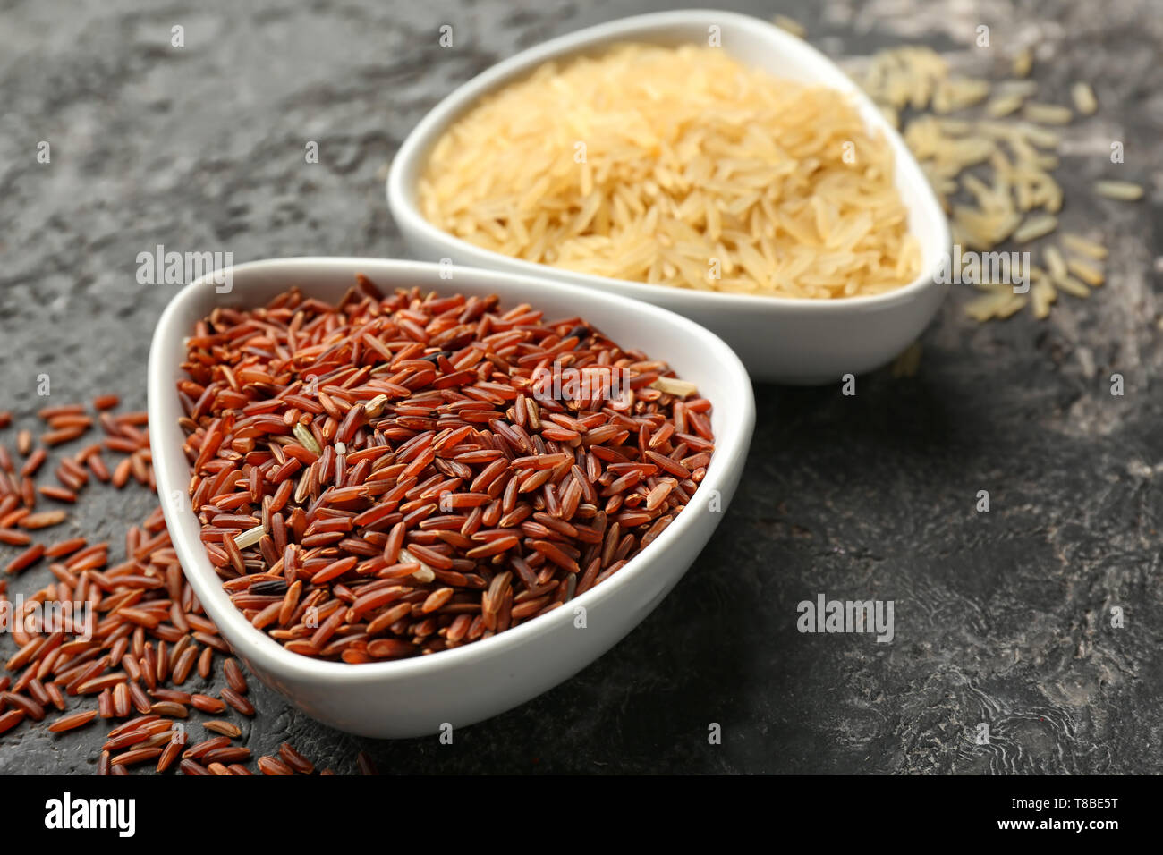 Different types of rice in bowls on grey background Stock Photo - Alamy