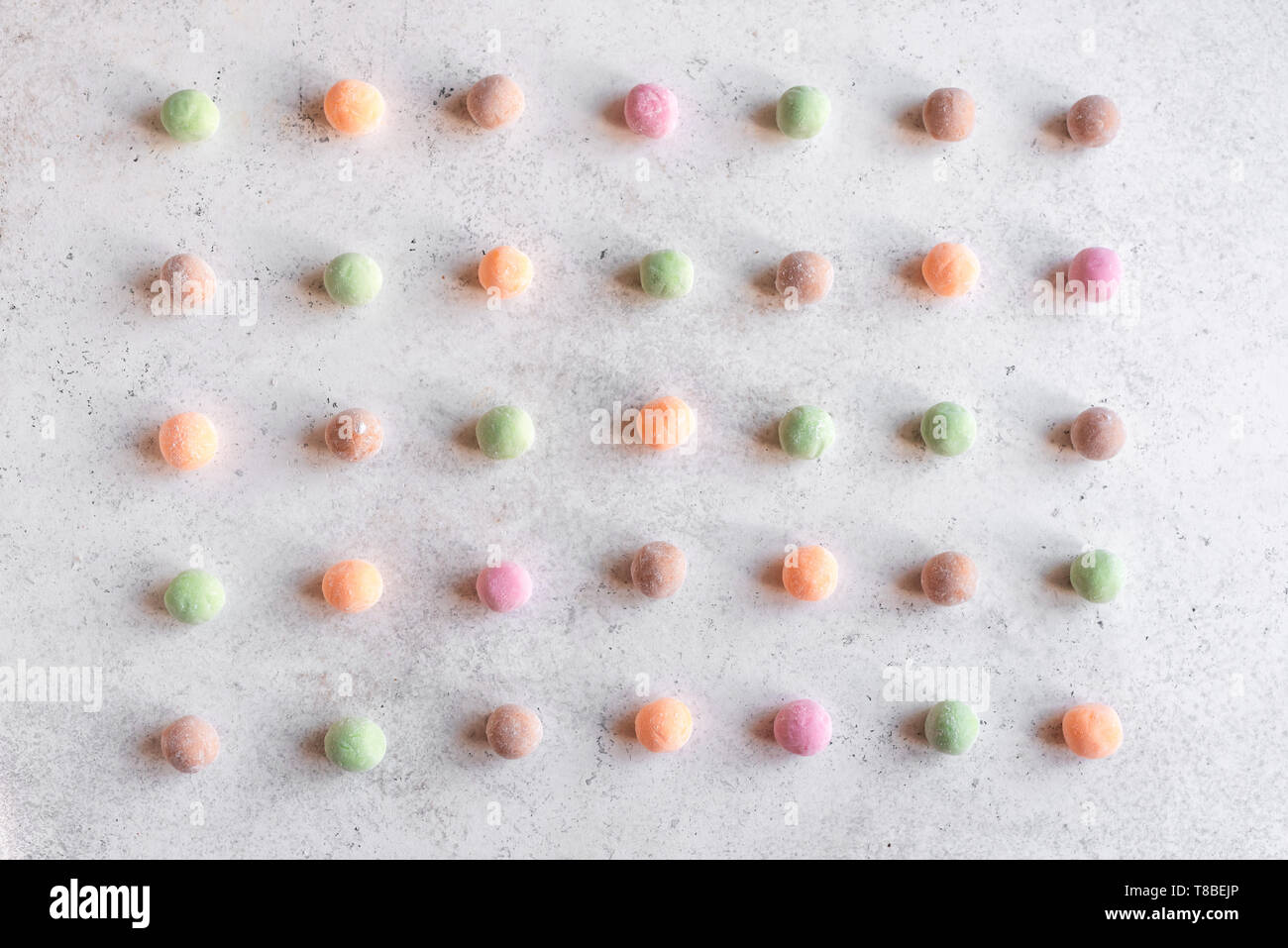 Mochi - traditional japanese dessert, rice cakes in rows on white table, top view, pattern. Stock Photo