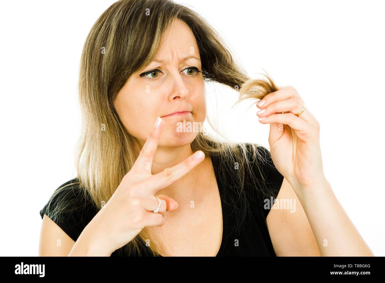 Blond woman - housewife - having problem with long straight hairs - frayed  hair ends - gesture of hair cut and hair stylist needed - white background  Stock Photo - Alamy