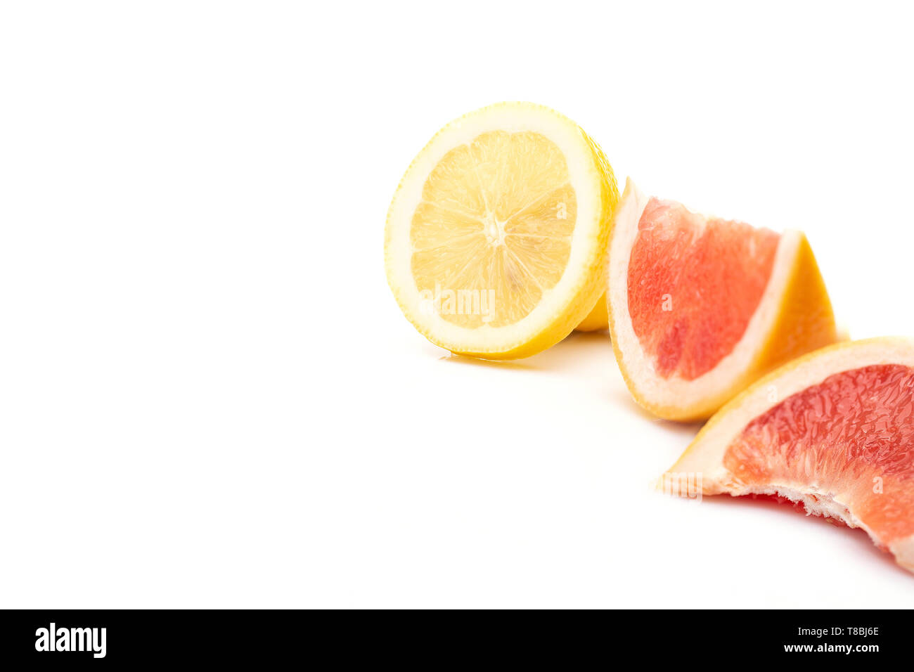 Fresh citrus fruits and food high in vitamin c concept theme with close up on a pile of mixed fruit with lemon and grapefruit sliced in half isolated  Stock Photo