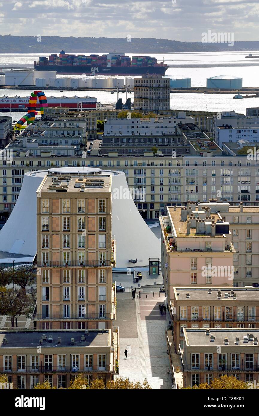 France, Seine Maritime, Le Havre, Downtown rebuilt by Auguste Perret listed as World Heritage by UNESCO, Perret buildings around the cultural center called Volcano created by Oscar Niemeyer, a container ship in the background leaves the commercial port Stock Photo