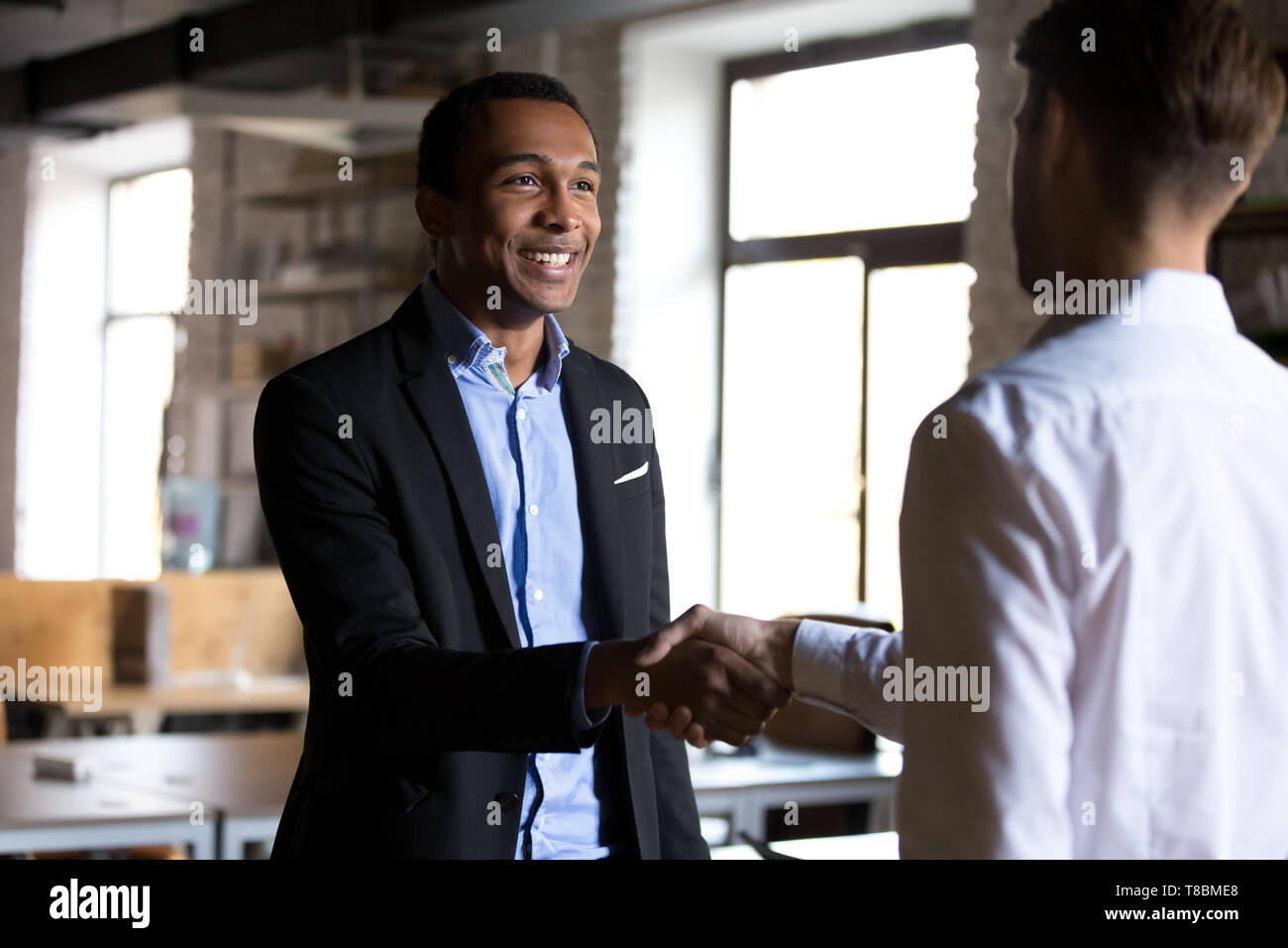 Boss shaking hands greeting new employee or company client Stock Photo ...