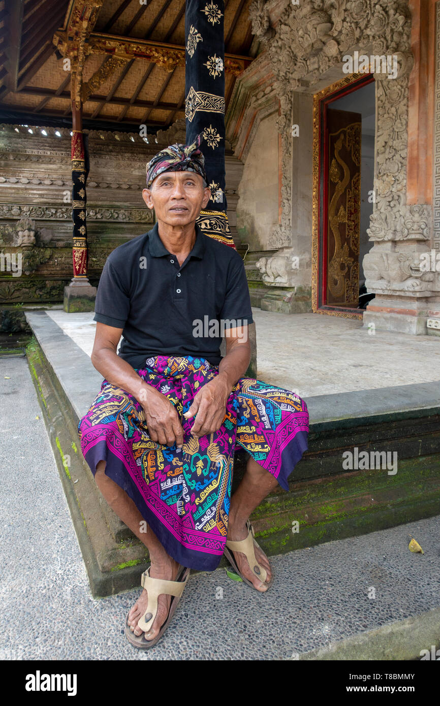 Balinese Men wearing Udeng headdress or a Balinees ikat kepala and is sitting at the floor of the temple Stock Photo