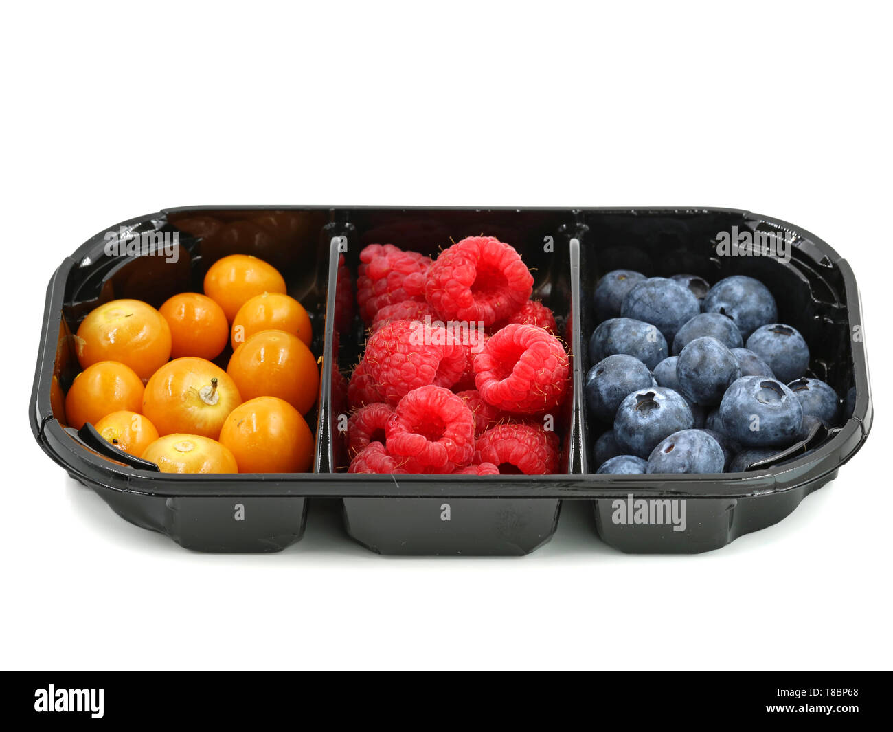 raspberries, blueberries and berries of physalis in black container isolated on white background Stock Photo