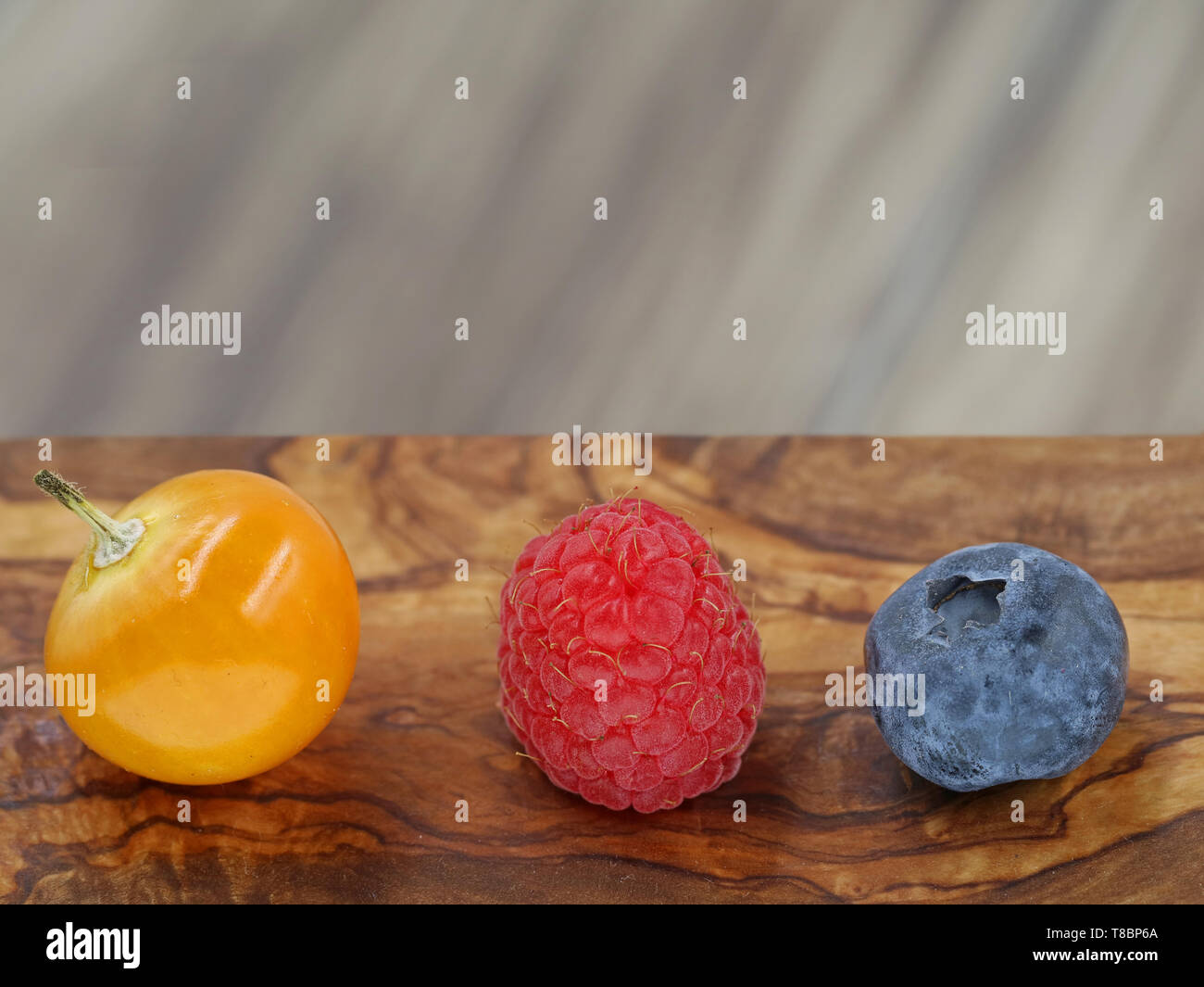 close up of raspberry, blueberry and berry of physalis on wooden background with copy space Stock Photo