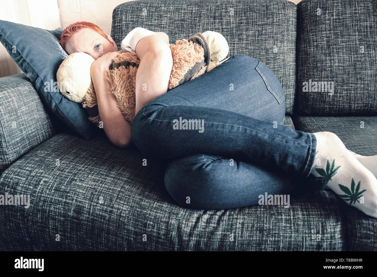 Girl saddened. Absolute solitude. Top view of depression unhappy sad man sitting hugging pillow feeling unnecessary. Stock Photo