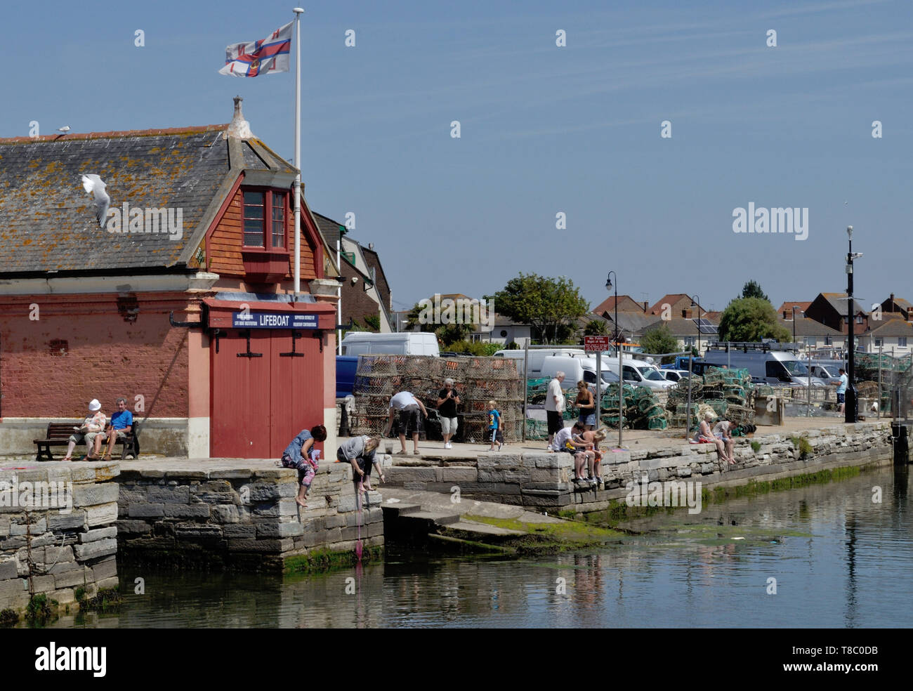 People crab fishing by the former RNLI lifeboat station, now a museum