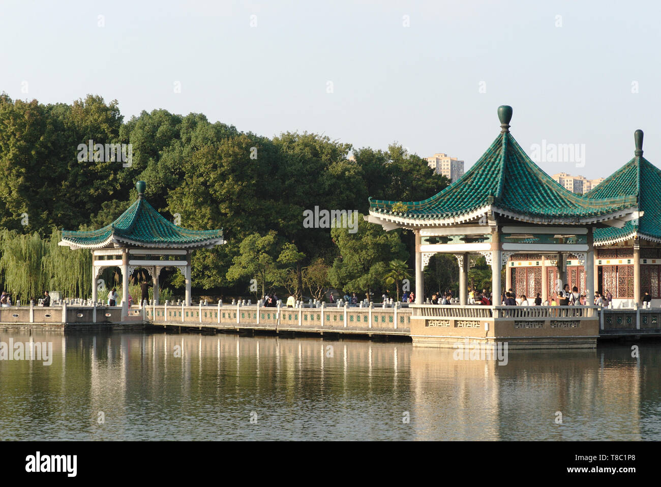 Pavilions with walking local people, East Lake scenic area, Wuhan, China Stock Photo