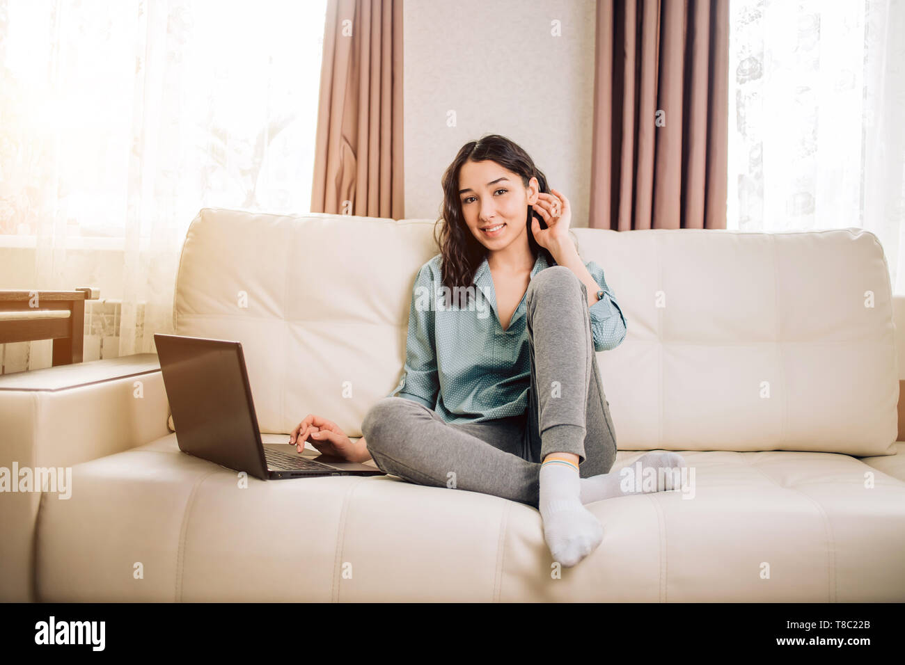 Relaxed Female Freelancer Touching Her Dark Wavy Hair During