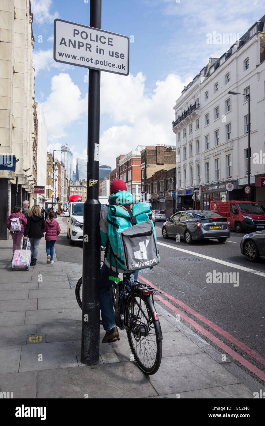 A male Deliveroo cyclist on Borough High Street, London, UK Stock Photo