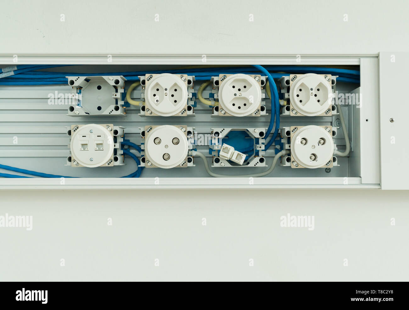 horizontal view of large unfinished electrical panel with sockets for