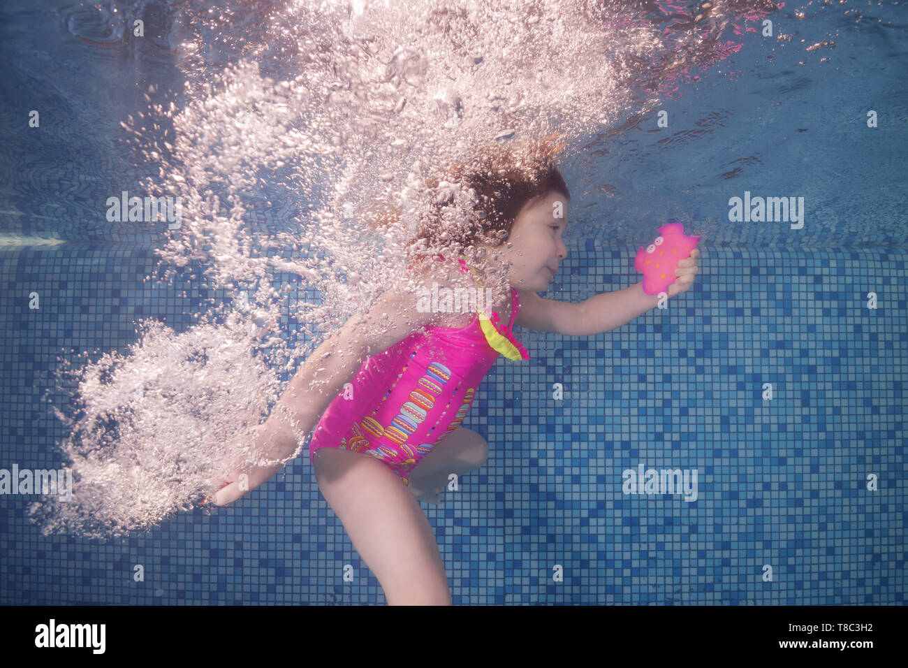 Girl In Pink Swimsuit Playing Underwater In The Pool Floats And Spins Among The Air Bubbles Healthy Family Lifestyle And Children Water Sports Activi Stock Photo Alamy
