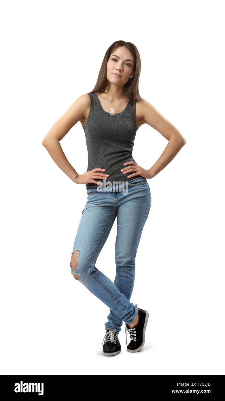 Young woman in gray sleeveless top and blue jeans standing with hands on  hips and one leg in front of the other isolated on white background Stock  Photo - Alamy