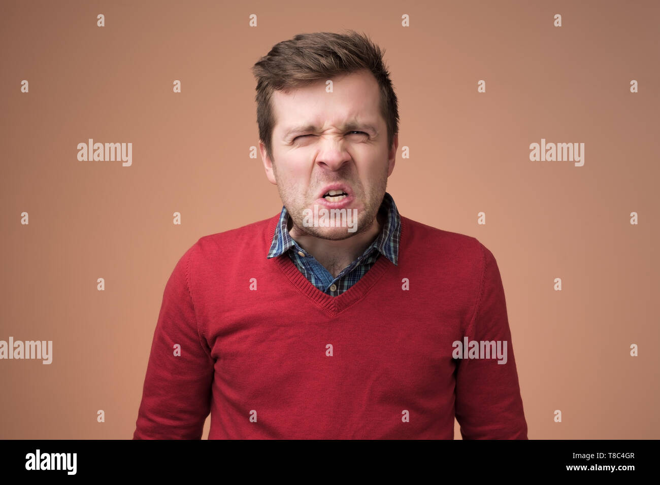 Angry caucasian man frowning his face in furious expression. Stock Photo