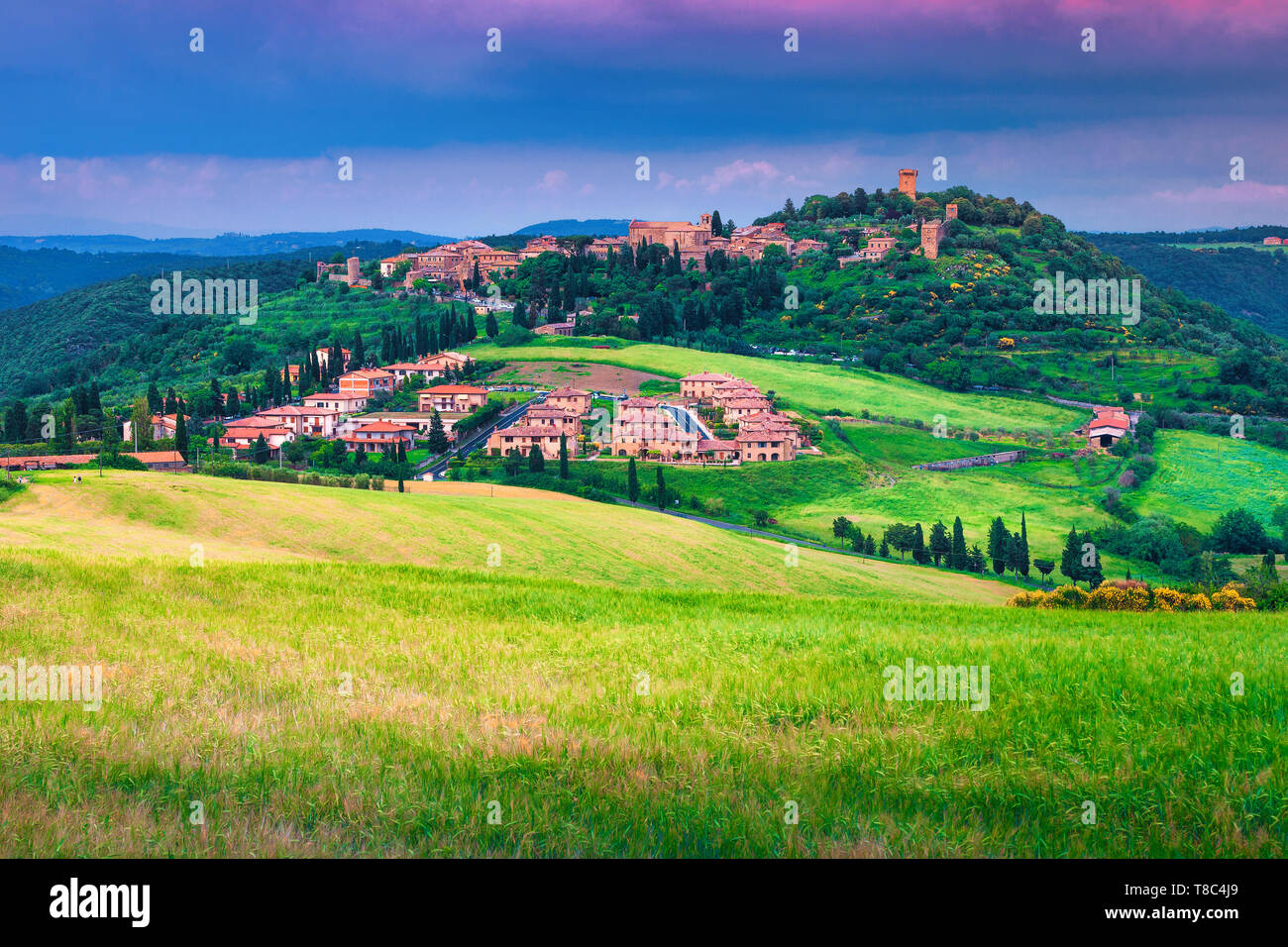 Fantastic travel and touristic location. Beautiful summer Tuscany cityscape. Monticchiello village on the hill with grain fields, Tuscany, Italy, Euro Stock Photo