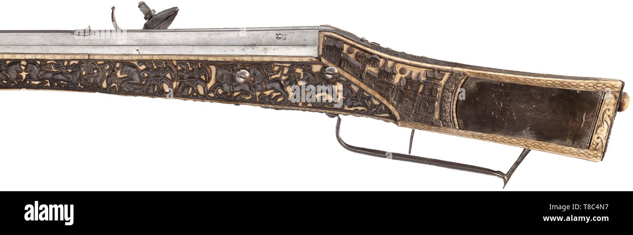 An extremely rare German wheel-lock gun, the stock veneered in bone overlaid with carved relief panels of Alpine Ibex horn (Steinbock) dated 1587. With heavy sighted smoothbore barrel formed in two octagonal stages, the portion towar 16th century, Additional-Rights-Clearance-Info-Not-Available Stock Photo