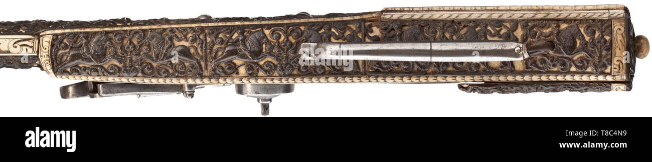 An extremely rare German wheel-lock gun, the stock veneered in bone overlaid with carved relief panels of Alpine Ibex horn (Steinbock) dated 1587. With heavy sighted smoothbore barrel formed in two octagonal stages, the portion towar 16th century, Additional-Rights-Clearance-Info-Not-Available Stock Photo