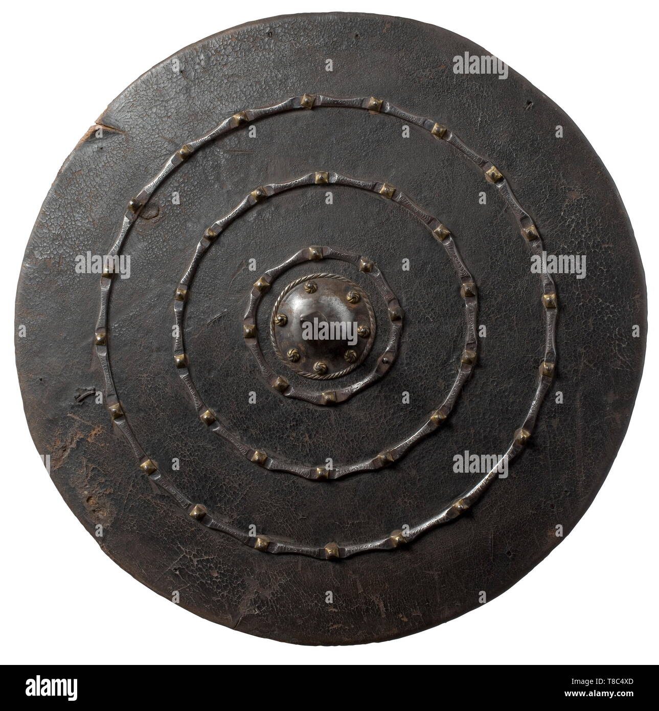 An Italian wooden round shield, 2nd half of 16th century Wooden round shield covered with leather and parchment. Three nailed iron rings and central, cut spike of quadrangular section at front, the nails with decorative, spirally engraved and pyramid-shaped brass washers. Remains of grip at back. Signs of age and use. Diameter 50.5 cm. historic, historical, defensive arms, weapons, arms, weapon, arm, fighting device, object, objects, stills, clipping, clippings, cut out, cut-out, cut-outs, utensil, piece of equipment, utensils, Additional-Rights-Clearance-Info-Not-Available Stock Photo