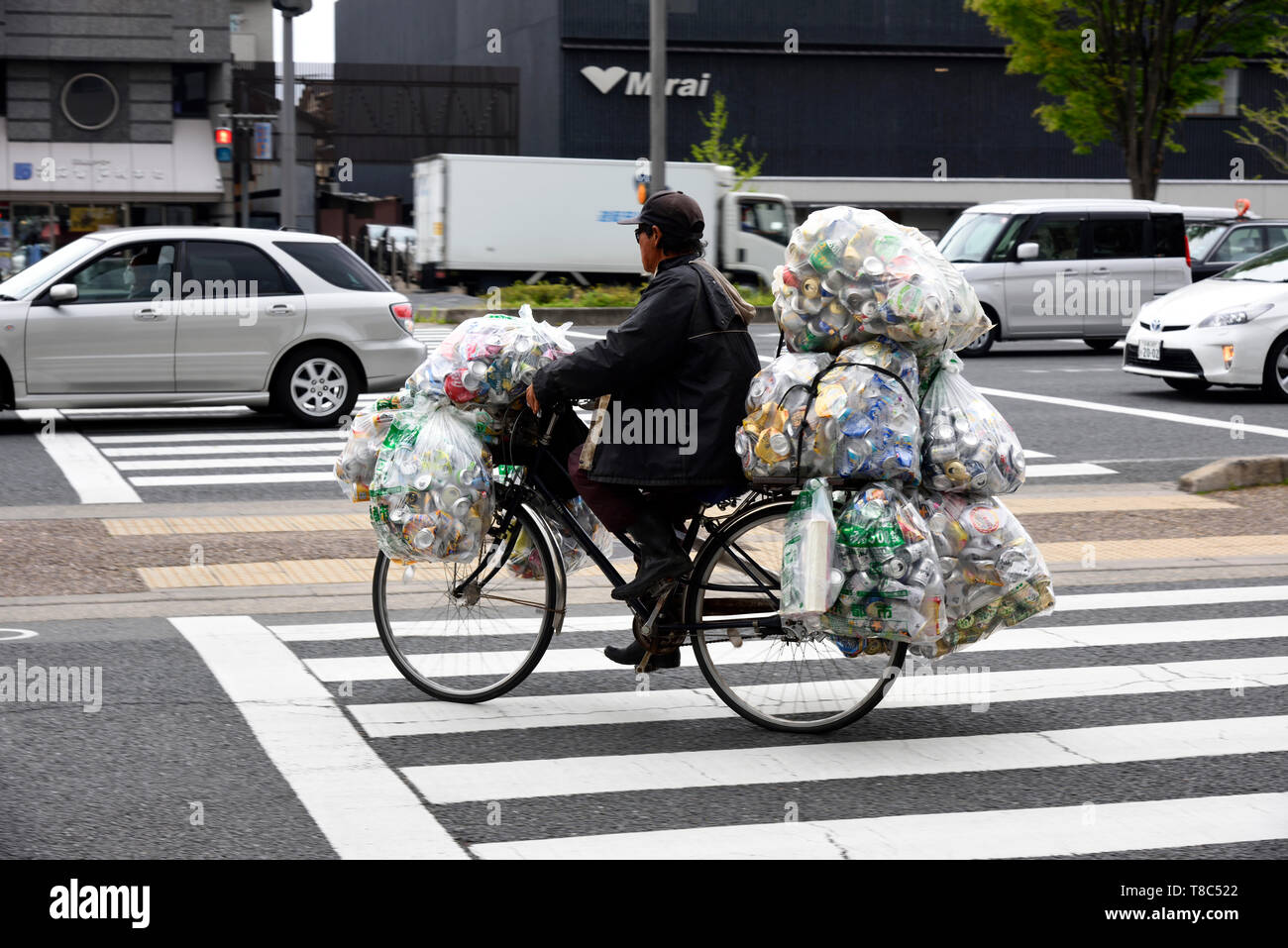 cyclist transporting bags for recycling Japan Stock Photo