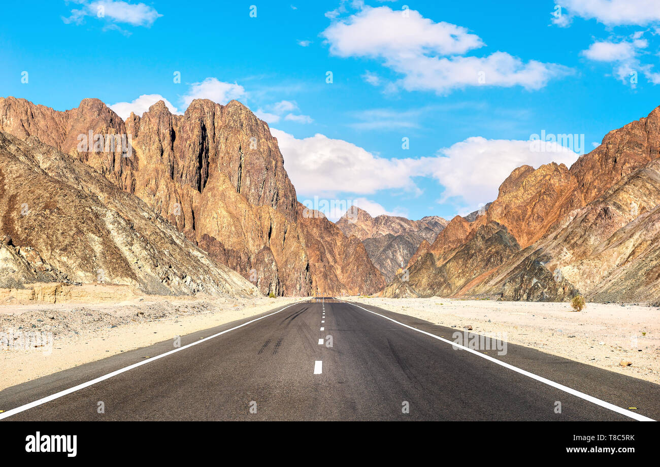 Asphalted road and high mountains in Egyptian desert Stock Photo