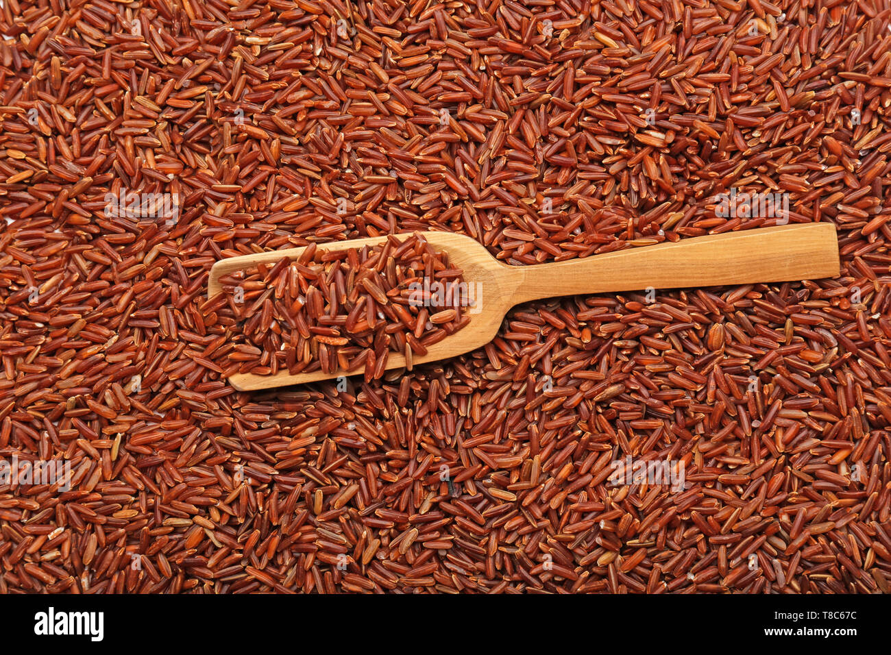 Wooden scoop on red rice Stock Photo - Alamy