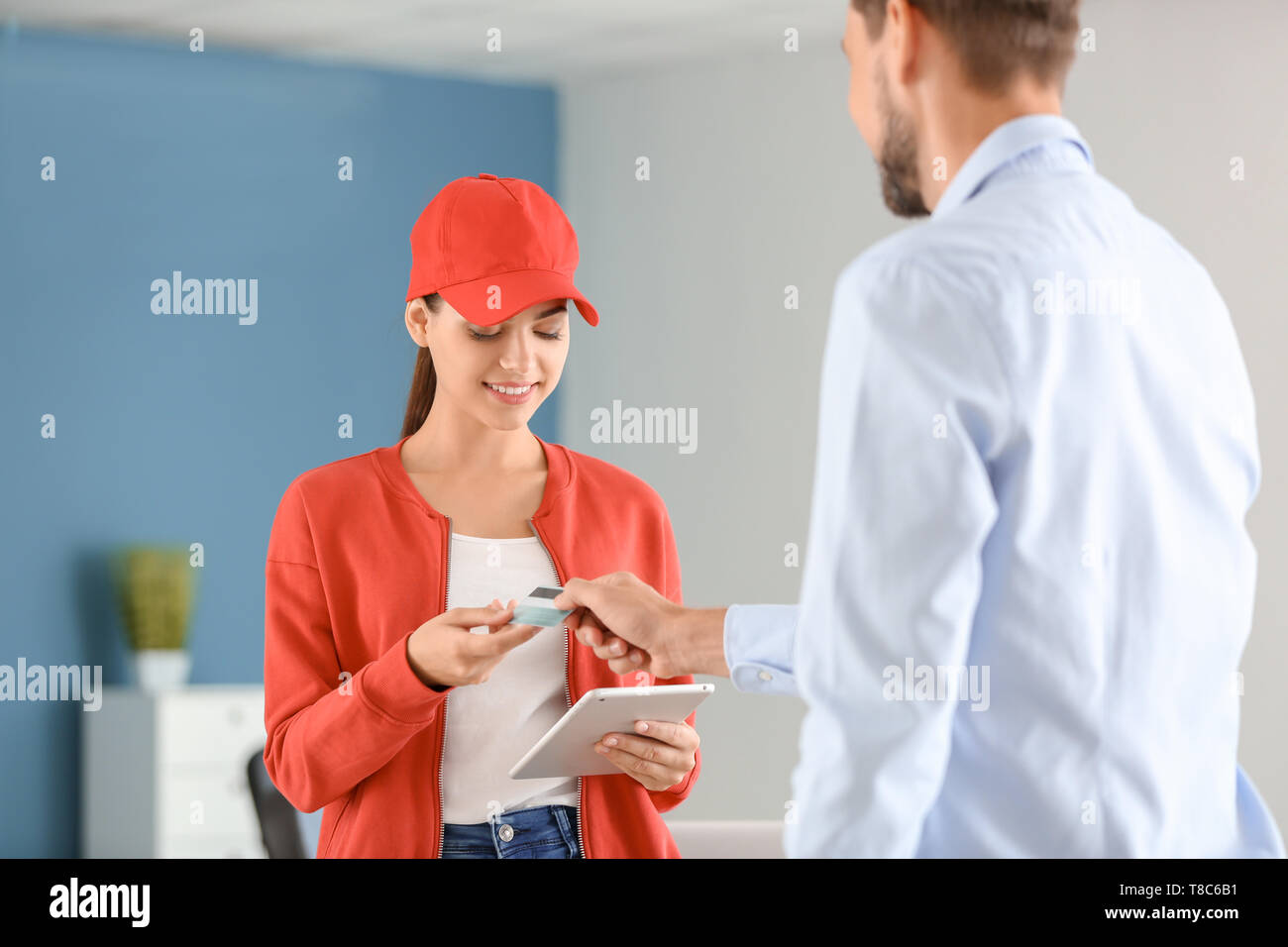 Man paying for delivery with credit card indoors Stock Photo - Alamy