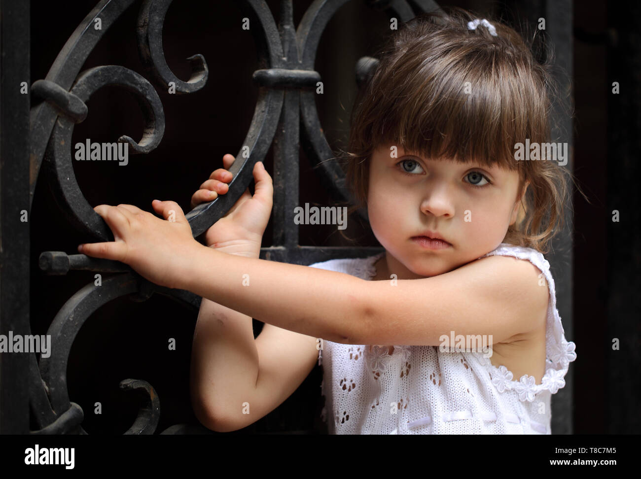 Little girl stands in front of the door Stock Photo - Alamy