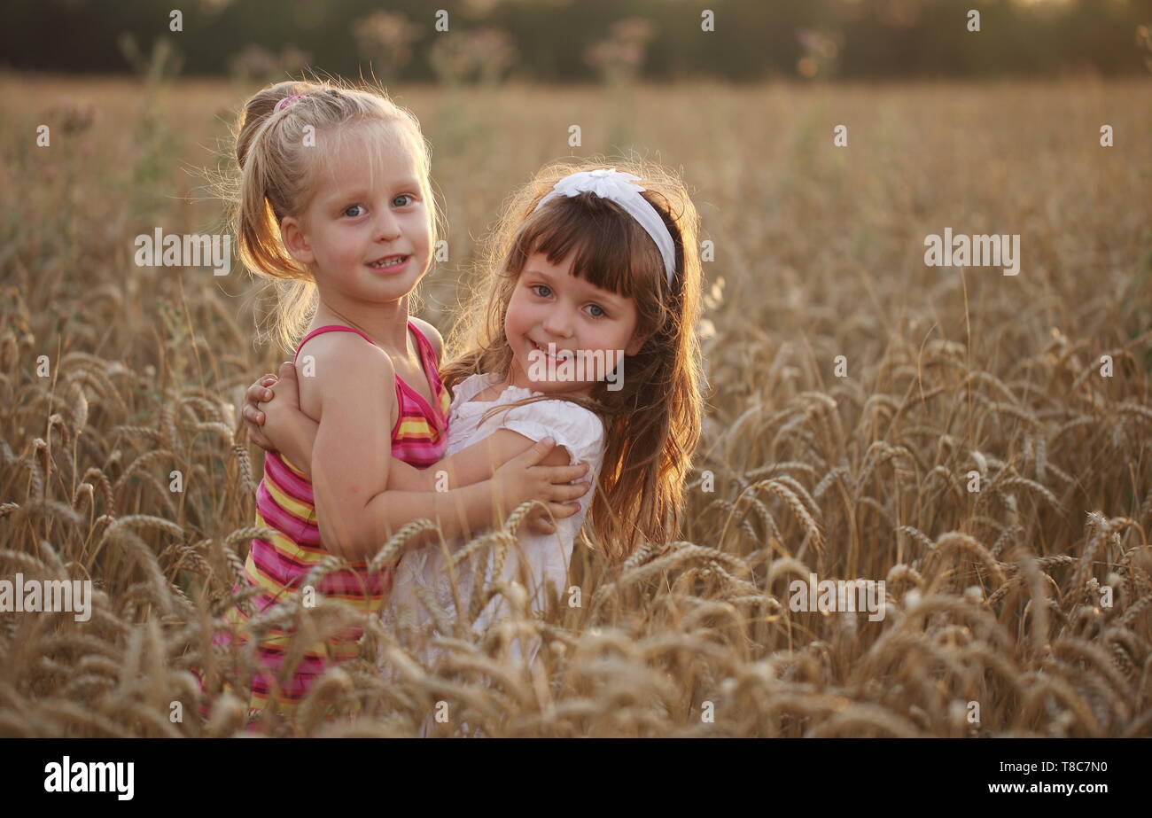 Two young children playing in a wheat field Stock Photo - Alamy