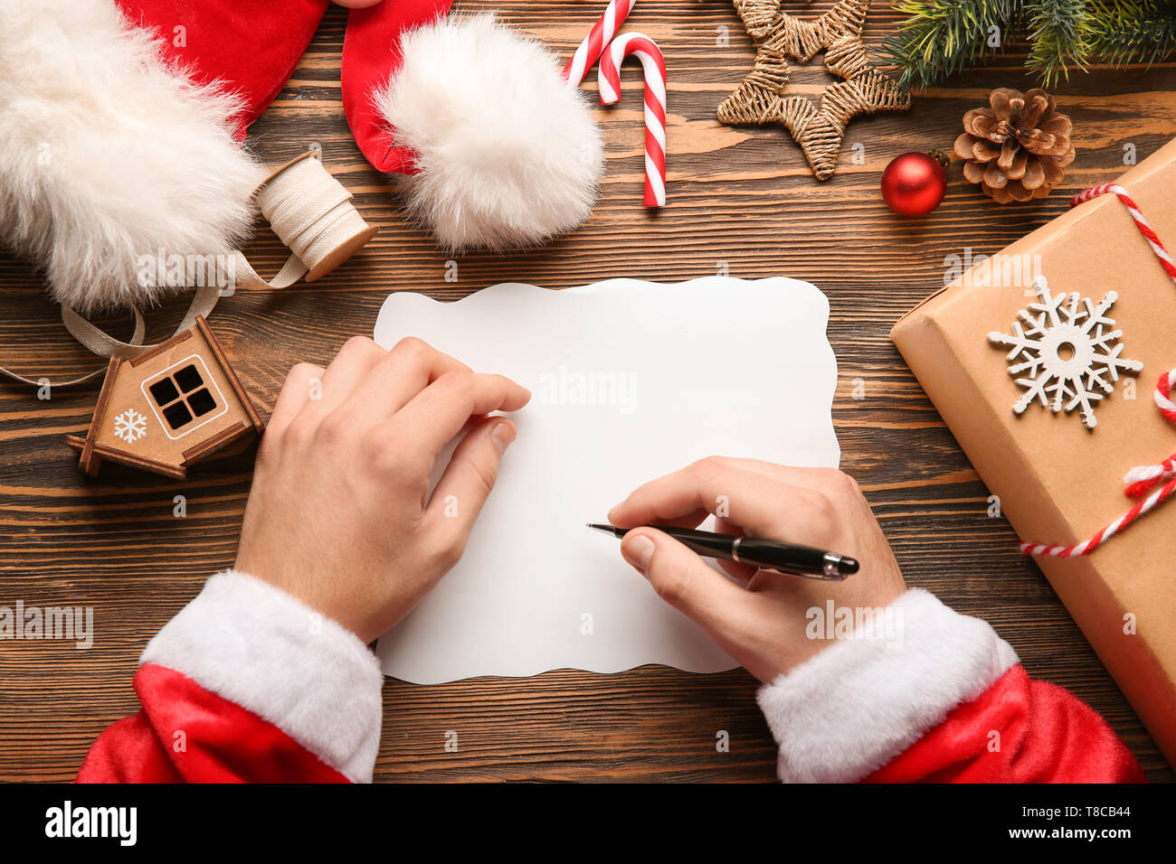 Santa Claus writing letter on wooden table Stock Photo - Alamy