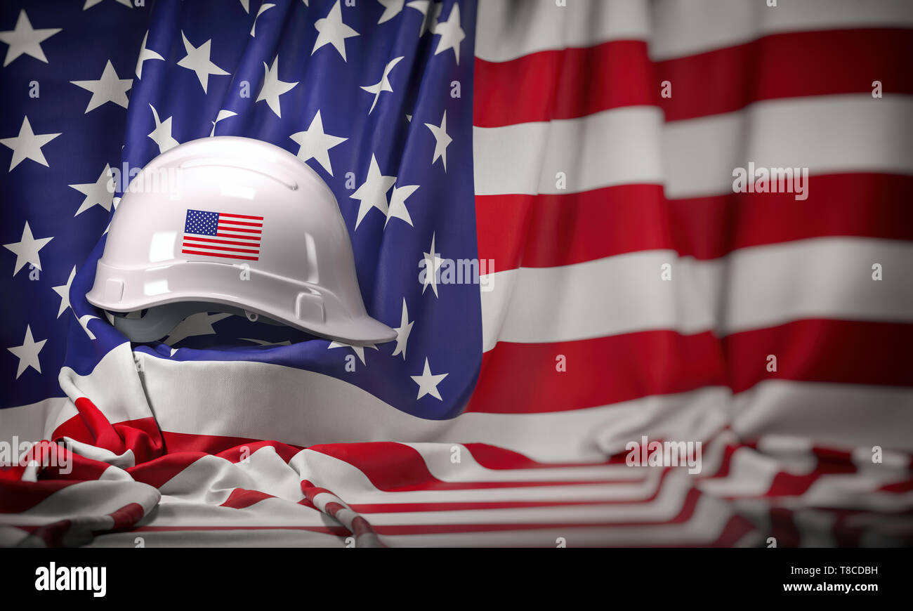 White hard hat laying over USA flag. Construction and employment in