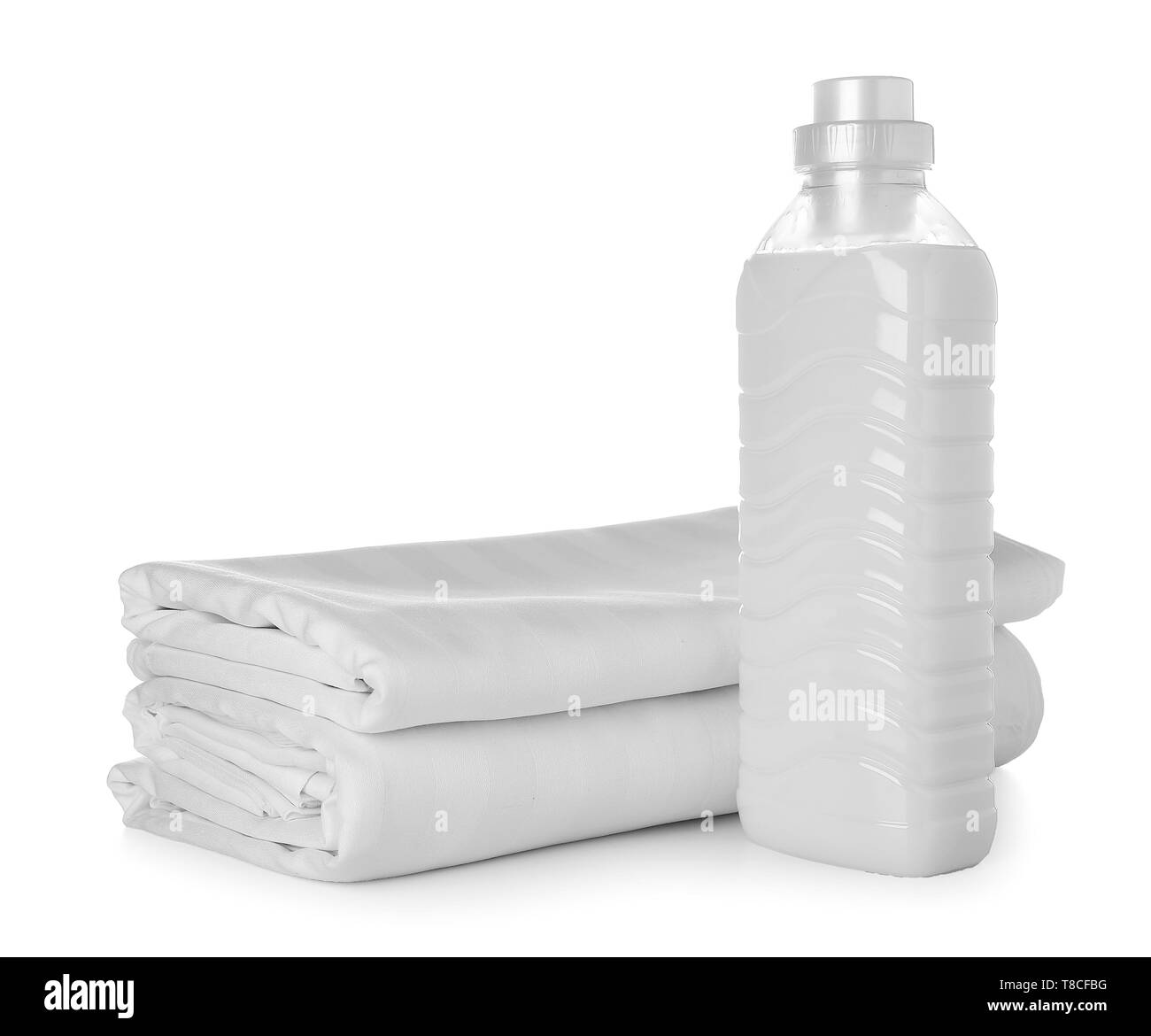 Stack of clean bed sheets and bottle with detergent on white background Stock Photo