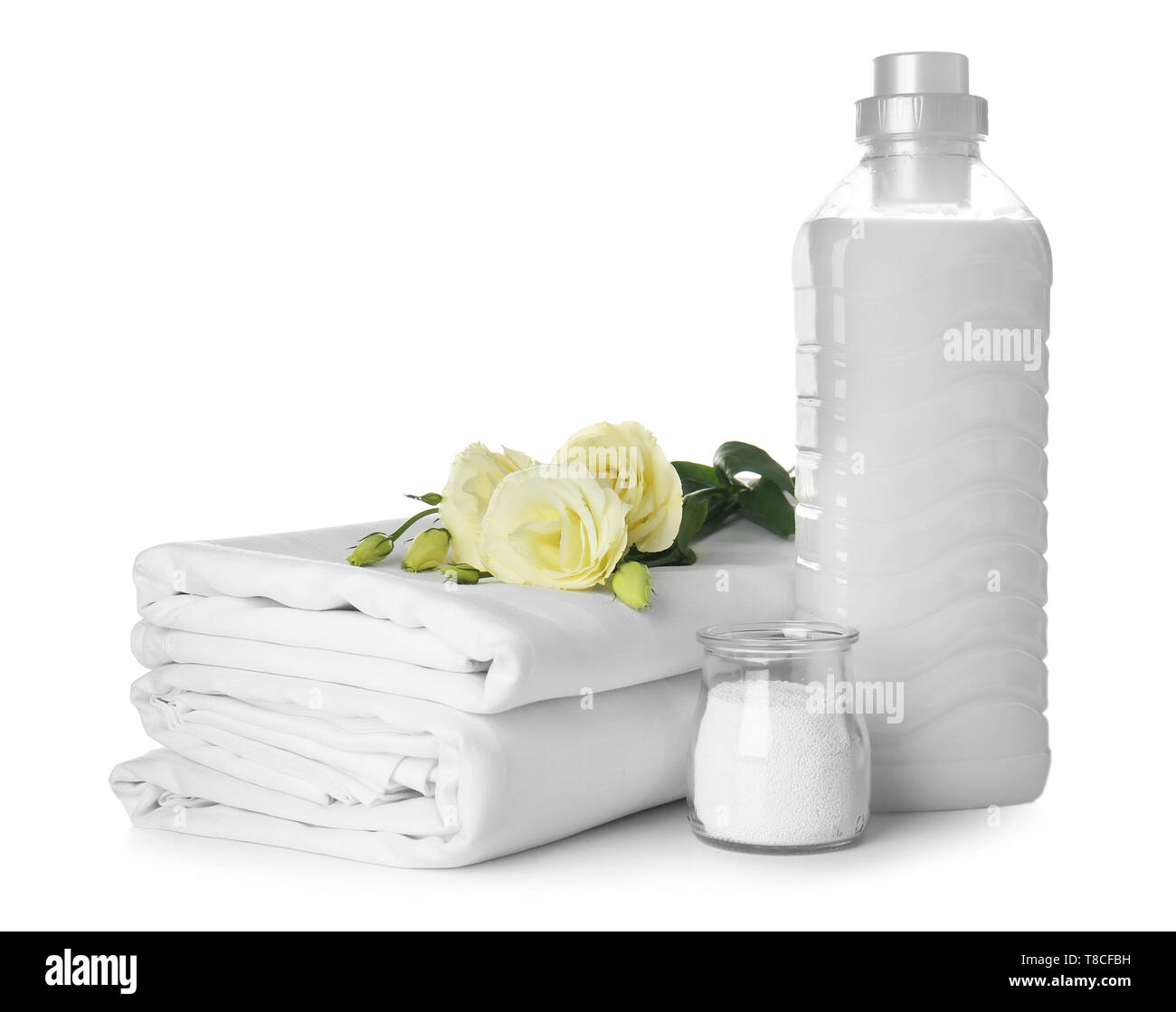 Stack of clean bed sheets and washing detergents on white background