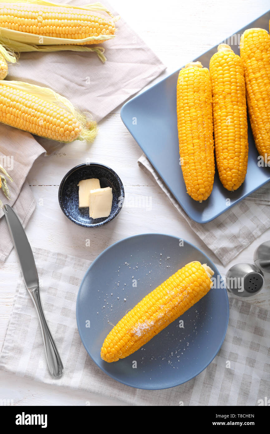 Composition with boiled corncobs on wooden table Stock Photo