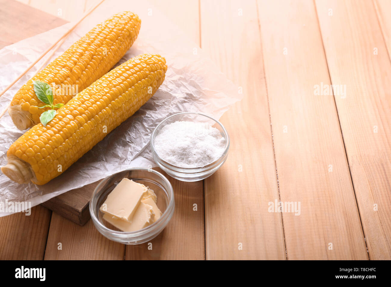 Composition with boiled corncobs on wooden table Stock Photo