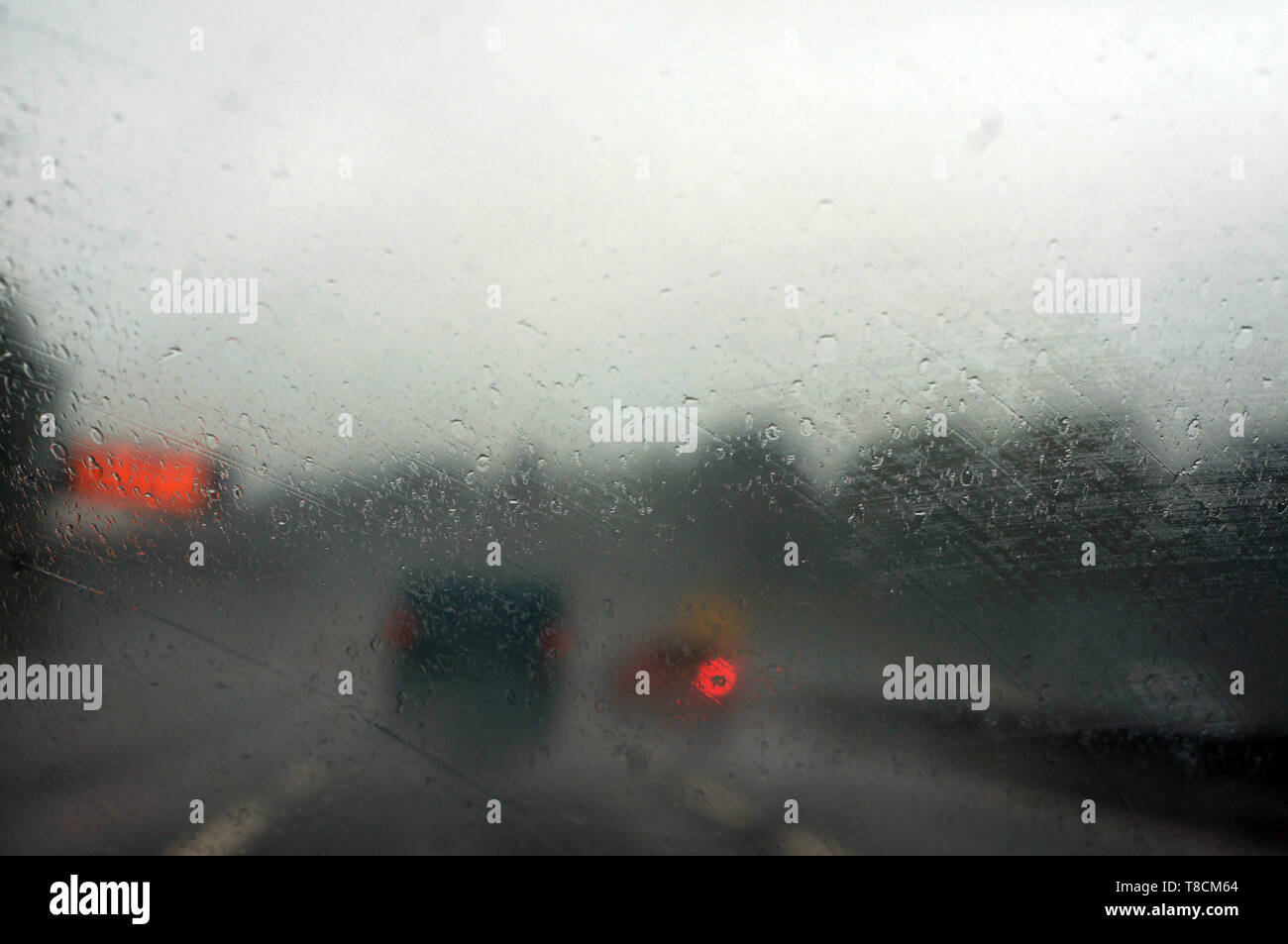 Raindrops on a car window with blurred background of traffic lights ...