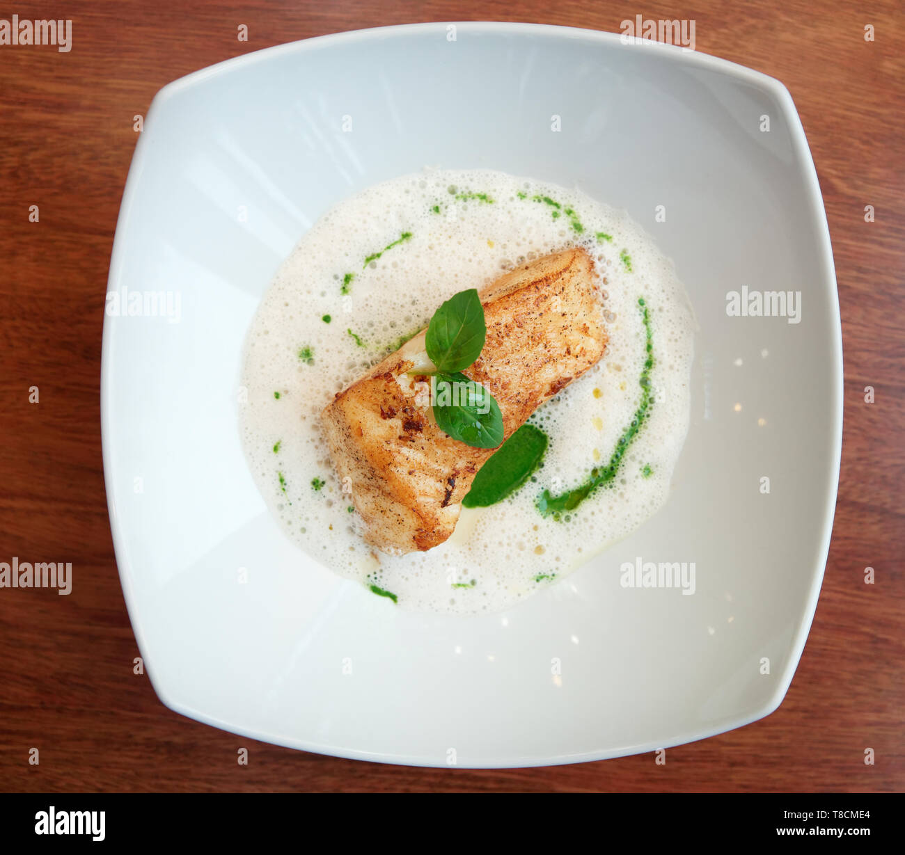 Braised fish fillet with froth sauce shot from above Stock Photo Alamy