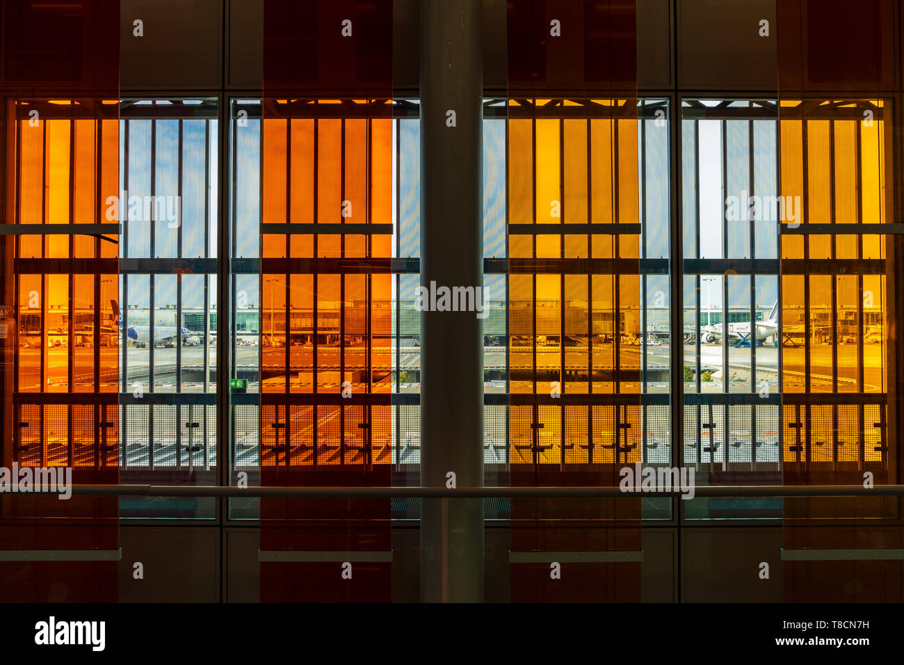 Charles De Gaulle Airport, France. Interior, Terminal 2E, departure lounge. Red and orange sun blinds hanging down and outside aircraft at terminal. Stock Photo