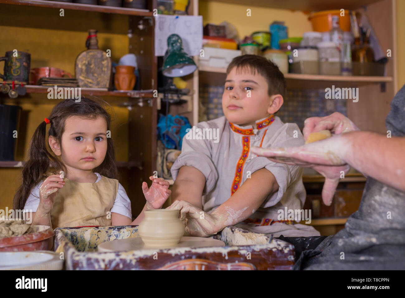 Pottery class and children trying to make ceramic wares in