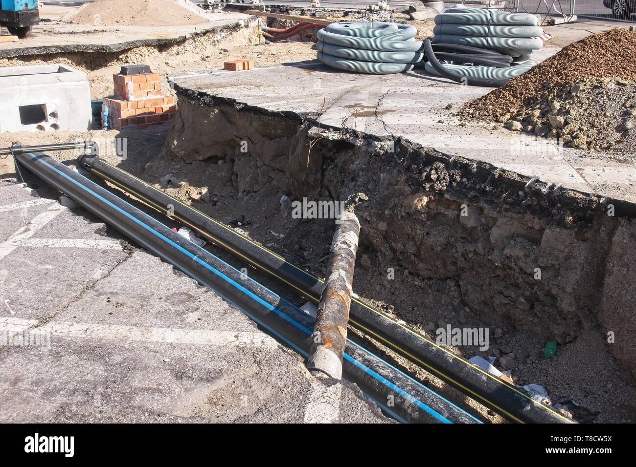 Construction industry. Road works. Excavation and laying of gas pipes. Laying of tubes for optical fiber. Stock Photo