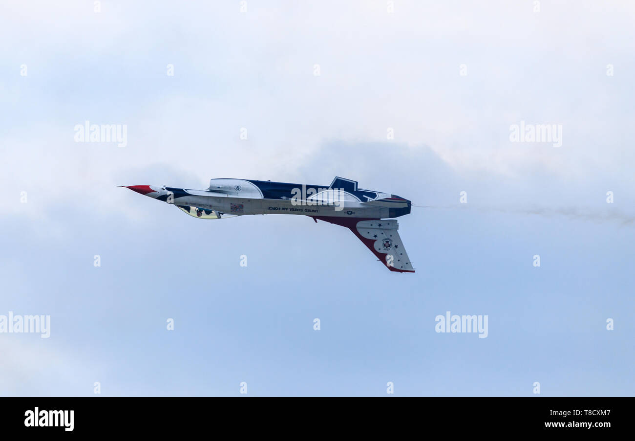 US Air Force Thunderbird buzzes by crowd upside down during a roll maneuver while performing for a crowd at JBA air base outside of Washington, DC. Stock Photo